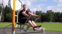 Träning på utomhusgym: person använder cykelfunktion på HAGS Flexo för benstyrka och kondition