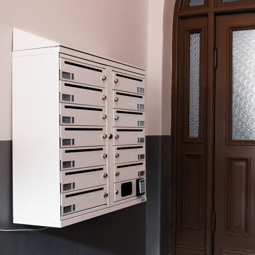 Vit fastighetsbox i trapphus entre Digital fastighetsbox i trapphus entré