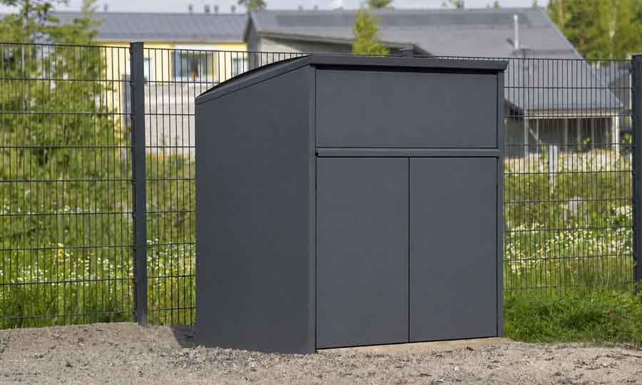 Mörkgrått kärlskåp med två dörrar placerat vid fastighet